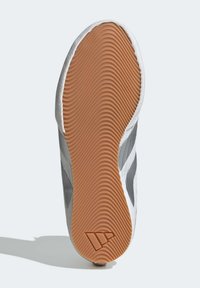 Urheilukengän pohja, jossa on beige kumimateriaali ja aaltoileva kuvio; päällinen on harmaata kangasta yksityiskohtineen.