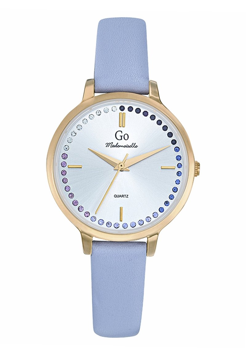 Montre ronde en quartz avec un cadran argenté, un boîtier doré, un bracelet en cuir lavande et des accents en cristal bleus et violets autour du cadran.