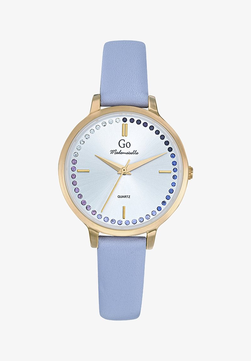 Montre ronde en quartz avec un cadran argenté, un boîtier doré, un bracelet en cuir lavande et des accents en cristal bleus et violets autour du cadran.