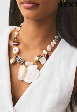 Necklace made with various seashells, pearls, and beads in pastel hues. Features gold-tone accents and a mix of textures and shapes.