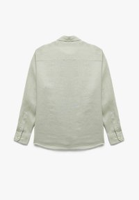 Camisa de lino verde claro con mangas largas, puños abotonados, cuello y dobladillo recto. Presenta una pieza trasera y una sutil textura en la tela.