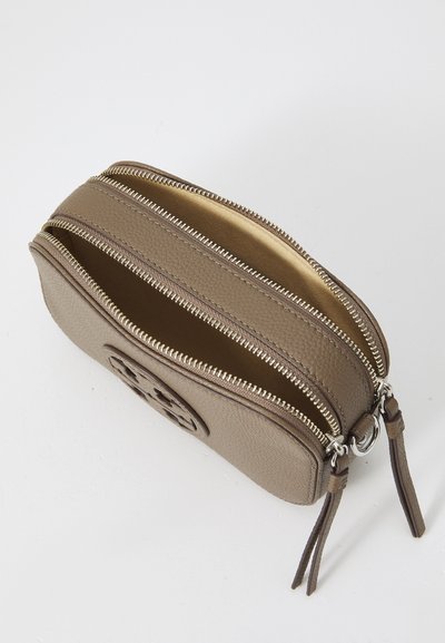 Pochette zippée en cuir beige avec deux compartiments, surface texturée, finition en métal argenté et un logo décoratif sur le côté.