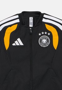 Black Adidas zip-up jacket with white stripes on shoulders, yellow panels, and the Deutscher Fußball-Bund logo with four stars on the chest.