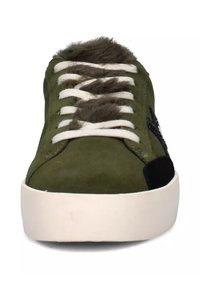 Sneaker verde in suede con lacci bianchi, linguetta in pelliccia sintetica, dettagli neri e suola spessa in gomma bianca. Design a punta arrotondata.