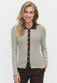 Randig cardigan i krämfärg och mörkbrun. Har en spetsig krage, långa ärmar och knäppning med metallknappar. Mjuk textur.