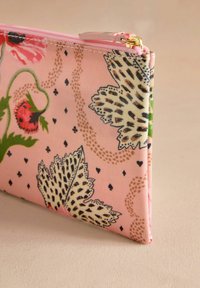 Saculeț de material roz cu modele florale și animale. Dispune de un fermoar auriu și o textură netedă. Formă compactă și dreptunghiulară.