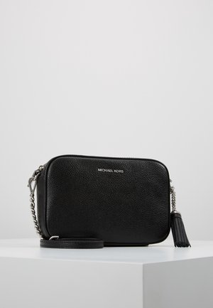 Sort tekstureret læder Michael Kors crossbody taske med sølvkæde og kvast detalje på hvid overflade.