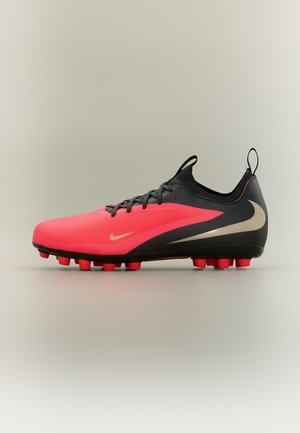 Chaussure de football noire et rouge vif avec lacets, languettes au talon et à la languette, et crampons rouges sur la semelle.
