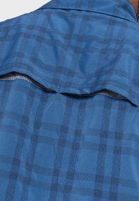 Blaues kariertes Hemd mit einer glatten Textur, das durch dunklere blaue Linien ein schachbrettartiges Muster bildet. Enthält einen Rückenbelüftung mit Netzfutter.