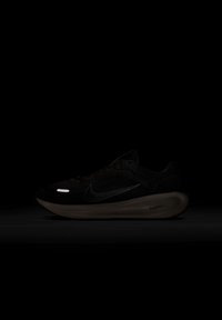 Čierna bežecká obuv Nike s textúrovaným zvrškom, reflexnými akcentmi a odpruženou podrážkou. Obsahuje odvážne logo a aerodynamický dizajn.