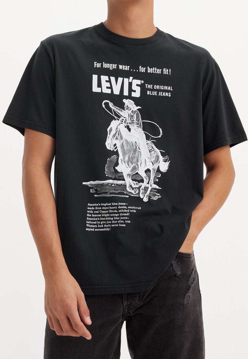 Czarna bawełniana koszulka z białą, vintage'ową grafiką przedstawiającą kowboja na koniu, z napisem szczegółowo opisującym cechy dżinsów Levi's.
