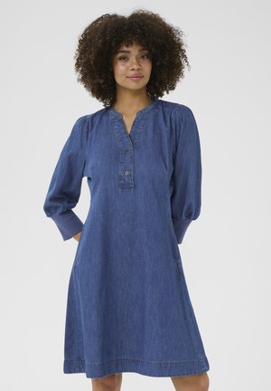 Denim jurk met pofmouwen, v-hals en knopen detail. Bevat zijzakken en een rechte snit, in een middelblauwe wassing.