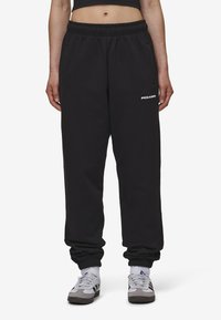 Zwarte sweatpants met een elastische tailleband, taps toelopende boorden en zijzakken. Voorzien van een wit "PEGADOR"-logo op de dij. Stof van een katoenmix.