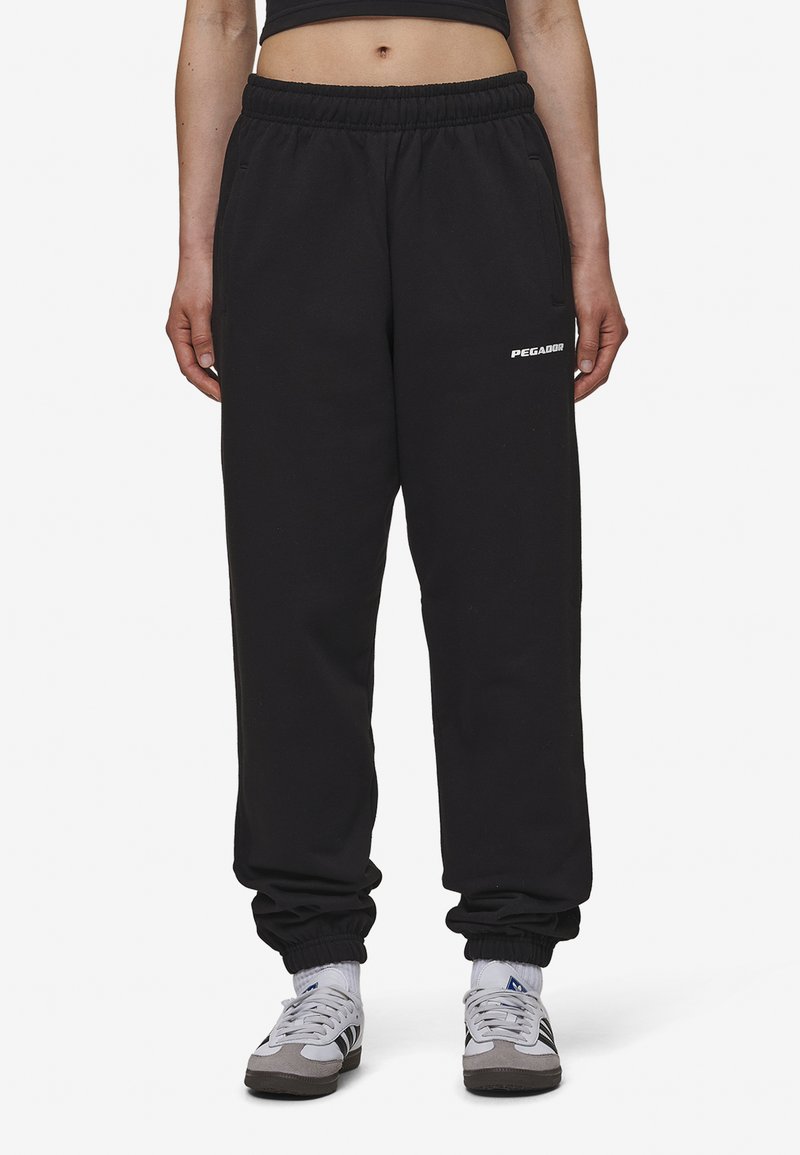 Zwarte sweatpants met een elastische tailleband, taps toelopende boorden en zijzakken. Voorzien van een wit "PEGADOR"-logo op de dij. Stof van een katoenmix.