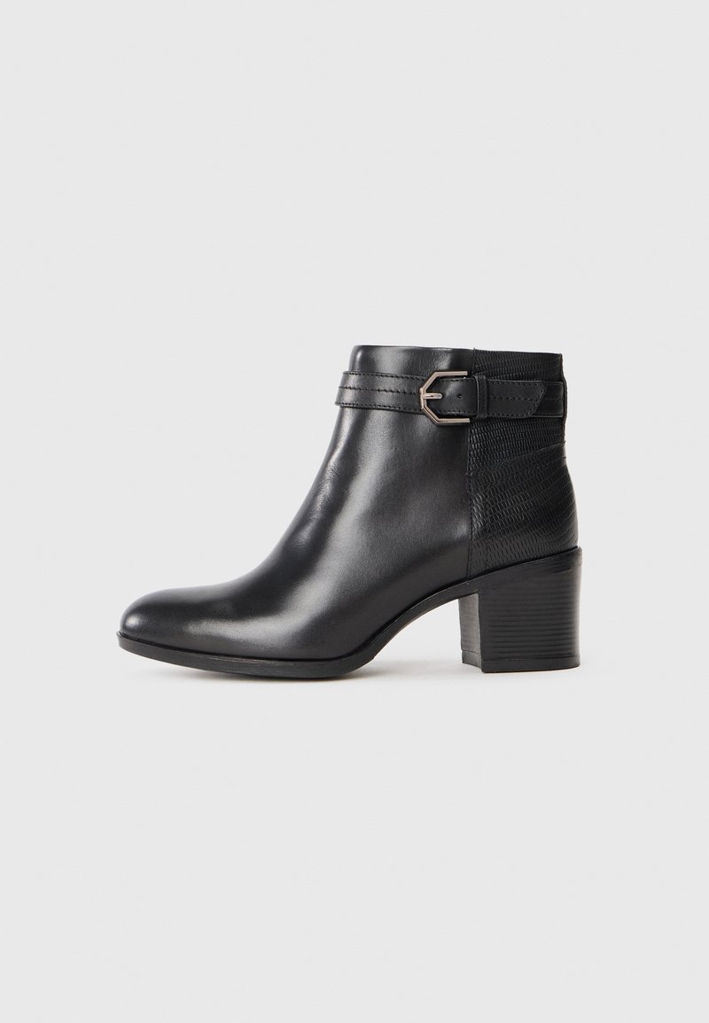 Botte cheville en cuir noir avec un bout arrondi, un petit talon carré et un détail de boucle décorative. Comprend un élastique sur les côtés pour plus de confort.