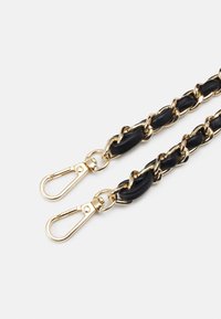 Bracelet en cuir noir avec des maillons et des clips en métal doré, présentant un design tressé. Texture lisse avec des accents métalliques brillants.