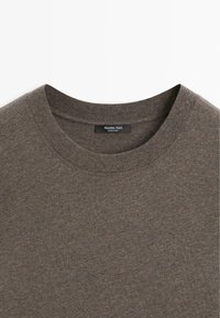 T-shirt a girocollo marrone realizzato in tessuto strutturato. Presenta un design semplice con un'etichetta che riporta "Massimo Dutti, Made in India."