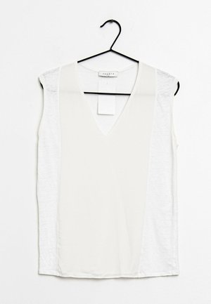 Blusa blanca sin mangas con escote en V colgada en una percha negra con etiqueta de marca y etiqueta de precio visibles.