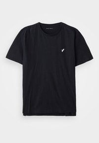 Μαύρο βαμβακερό μπλουζάκι με κανονικό λαιμό, κοντά μανίκια και μικρό λευκό λογότυπο πουλιού στο στήθος. Μονοχρωμία, μαλακή υφή, άνετη εφαρμογή.