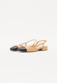 Kohvaprussid nahksete slingback-kingade, millel on must terav varvas. Madal plokknukk ja ristatud rihmad. Sile tekstuur minimaalse detailiga.