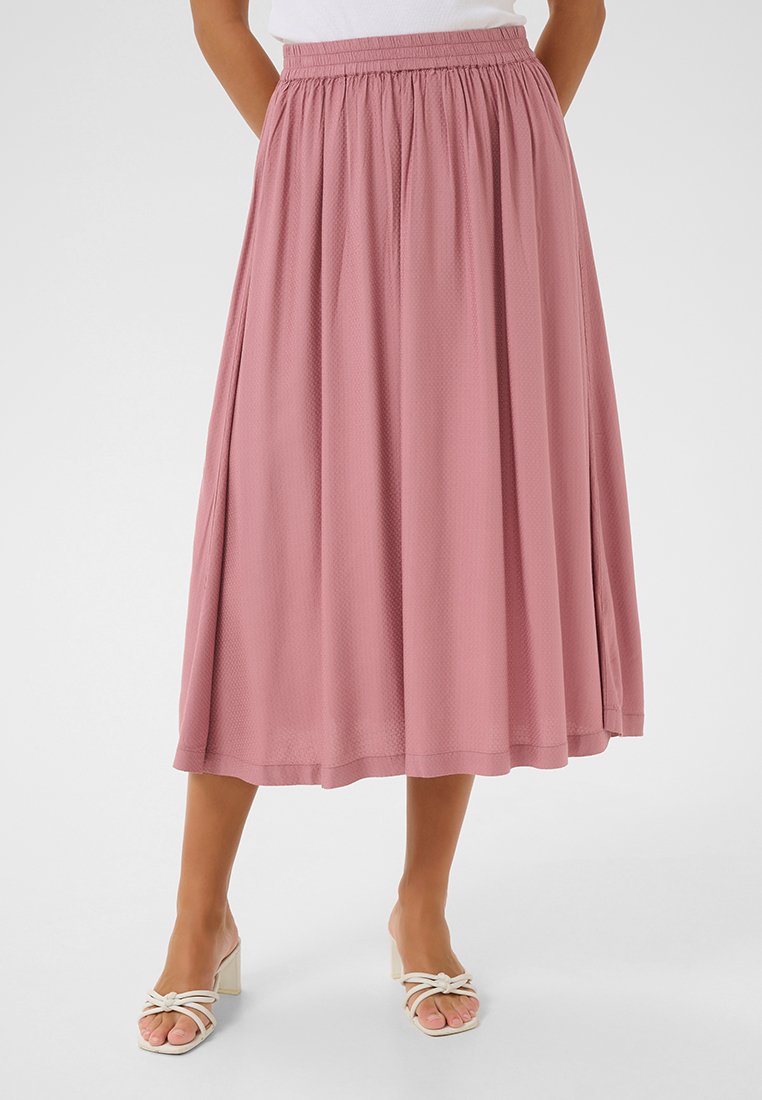 Jupe rose jusqu'aux genoux en tissu texturé avec une taille élastique, présentant une silhouette fluide et des détails de design subtils.