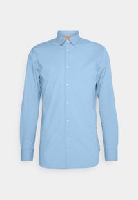 Ljusblå långärmad skjorta med knappar och spetsig krage samt orange detaljer på insidan av kragen. Har framknappar och raka manschetter.