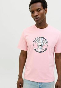 Rosa Baumwoll-T-Shirt mit einem grafischen Druck eines Schädels und Palmenblättern, versehen mit dem Text "JACK & JONES ORIGINALS" in einer kreisförmigen Anordnung.