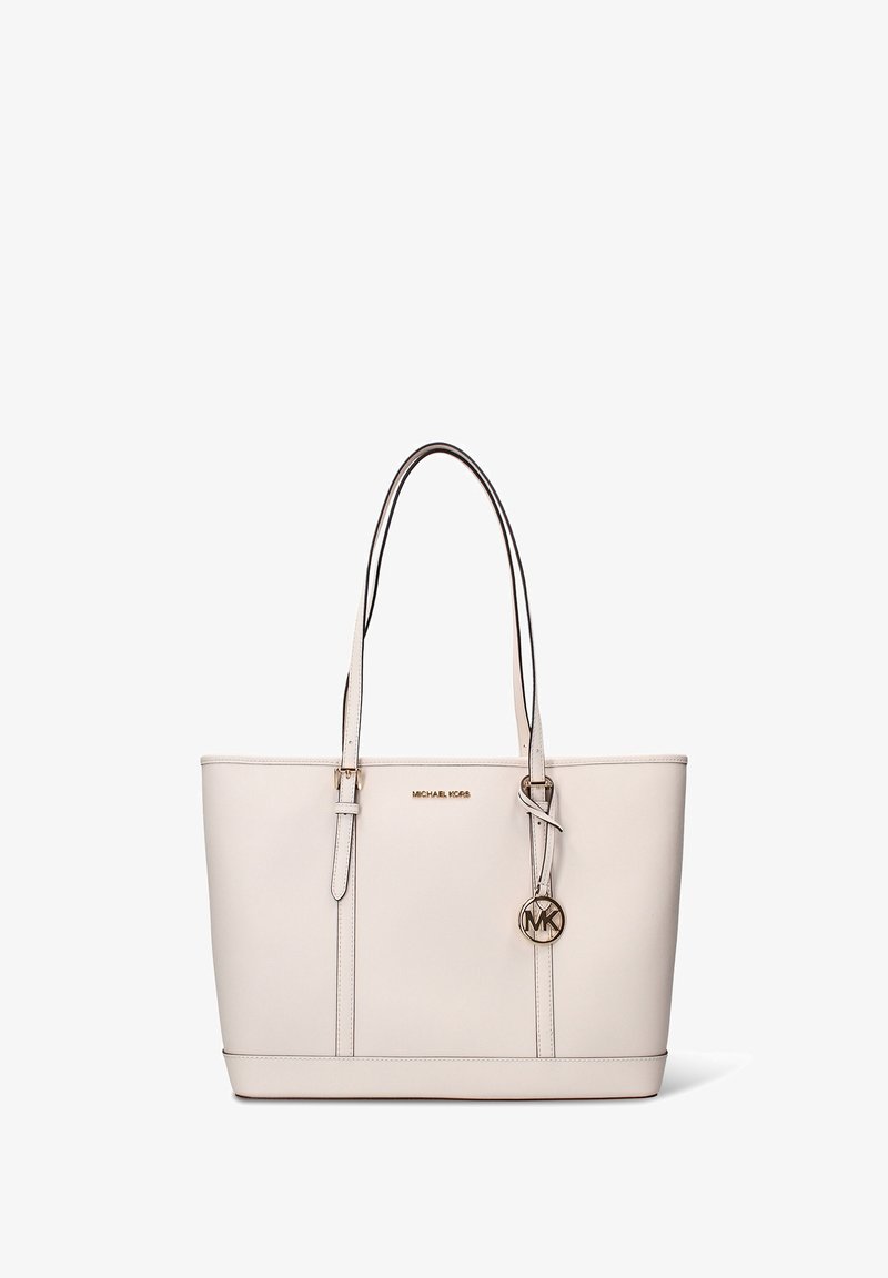 Sac fourre-tout en cuir beige avec deux poignées supérieures, logo doré et pendentif latéral. Texture lisse avec une silhouette structurée et des surpiqûres contrastées.