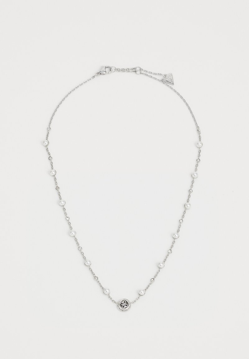 Collier en chaîne argentée avec de petites perles et des cristaux transparents espacés de manière uniforme, présentant un charm rond au design décoratif au centre.