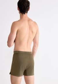 Olijf groene boxershorts van zacht materiaal, met een tailleband met subtiele logo-details, een aansluitend ontwerp en een lengte tot halverwege de dij.