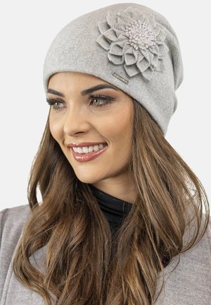 Gray knit beanie featuring a large, layered fabric flower adorned with beads on the side. Smooth texture and close-fitting design.
