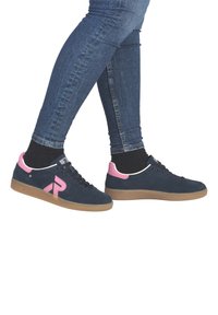 Granatowe zamszowe trampki z różowymi akcentami i gumową podeszwą. Charakteryzują się białą lamówką i logo po boku, sznurowanym designem oraz zaokrąglonym noskiem.