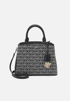 Sac à main monogramme DKNY noir et blanc avec doubles anses, bandoulière amovible et breloque DKNY dorée à l'avant.