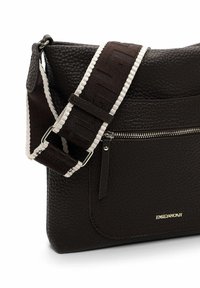 Brown textured leather bag with a zippered pocket, featuring a patterned adjustable shoulder strap in dark brown and white accents.