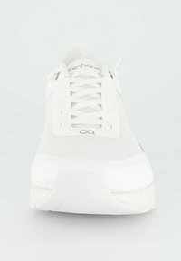 Bílé sportovní boty s síťovaným vrškem, plochými tkaničkami, polstrovaným límcem a měkkou podrážkou. Obsahují logo na boku a minimalistický design.