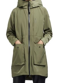 Olivgrön vattentät jacka med huva, med en frontdragkedja, två stora framfickor och justerbara ärmslut. Slät tygtextur.