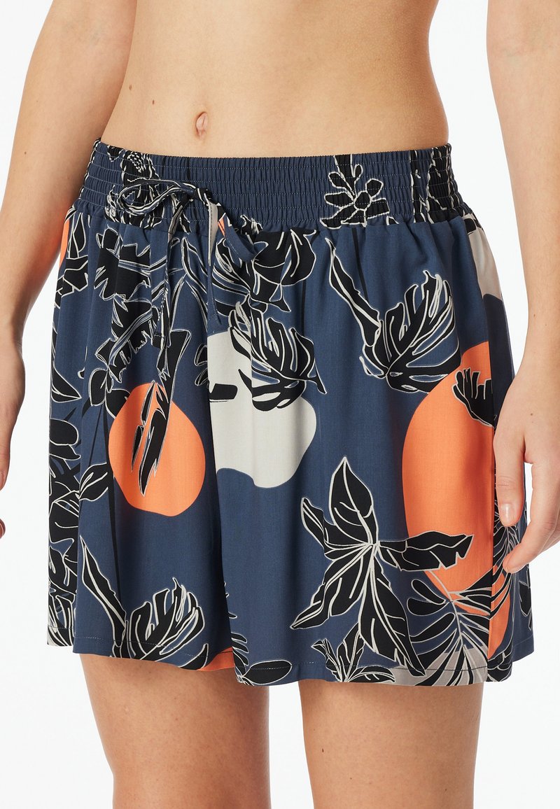 Námořnická modrá sukně s elastickým pasem, zdobená květinovým vzorem v černé a oranžové barvě. Lehká tkanina, uvolněný střih a detaily s tkaničkou.