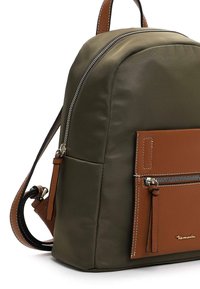 Sac à dos en nylon vert olive avec une poche avant en cuir brun, fermeture éclair argentée et accents beige. Texture lisse, forme arrondie et bretelles réglables.