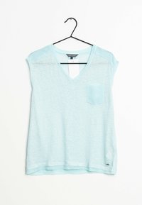 Top de manga corta en azul claro con escote en V, hecho de una tela suave y texturizada. Cuenta con un bolsillo en el pecho y un dobladillo curvado.