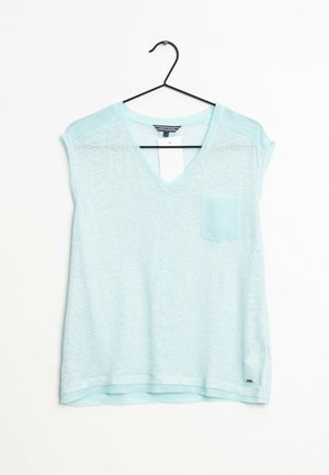 Jasnoniebieska bluzka o skróconych rękawach i dekolcie w kształcie V, wykonana z miękkiego, teksturowanego materiału. Posiada jedną kieszonkę na piersi oraz zaokrąglony dół.