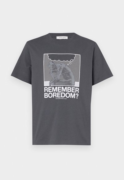 Pilkas medvilninis marškinėliai su grafikiniu printu, vaizduojančiu mąstytoją su mąstymo burbulu. Tekstas skaito "PRISIMENI NUOBODULĮ?" baltos spalvos. Klasikinis kirpimas ir trumpomis rankovėmis.