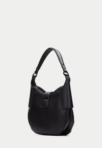 Svart läderaxelväska med en texturerad yta, utrustad med ett flätat handtag, ett säkert lock och en rundad form.