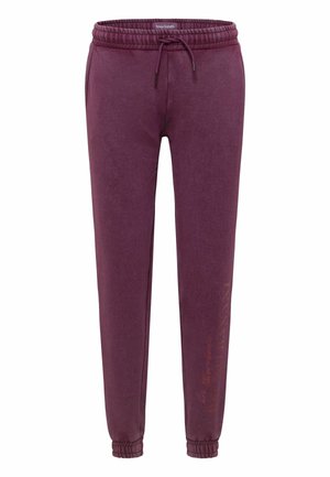 Bordeauxrote Jogginghose aus weichem Stoff, mit Tunnelzug am Bund, tapered Beinen und elastischen Bündchen, mit seitlichem Aufdruck.