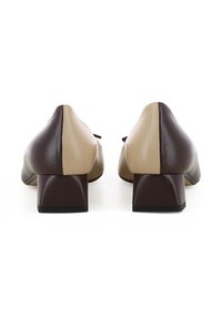 Bicolore leather pumps met een ronde neus, uitgerust met een beigerand aan de voorkant en een donkerbruine achterkant, en een blokhakdesign. Glad textuur, minimale detailing.