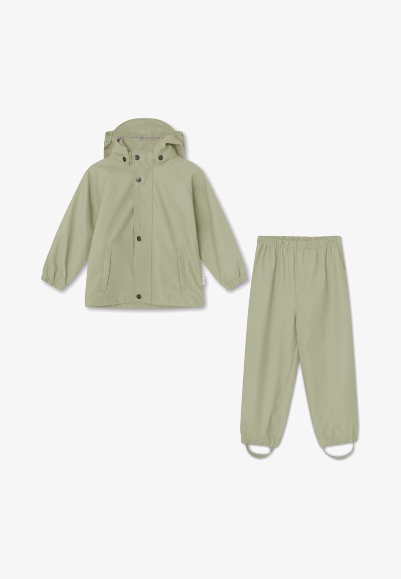 Světl zelená dešťová bunda s kapucí a knoflíky, spárovaná s odpovídajícími kalhotami na gumu v pase. Hladká, voděodolná tkanina s jednoduchým designem.