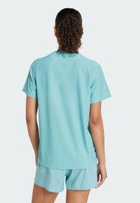 Un t-shirt ajusté à manches courtes de couleur bleu clair, avec une texture lisse et respirante, associé à un short bleu clair assorti.