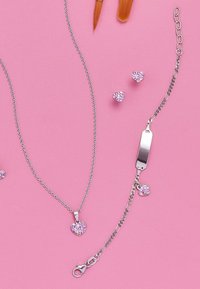 Set di gioielli composto da una collana in argento con un pendente a forma di cuore rosa, orecchini abbinati e un bracciale con un ciondolo a forma di cuore.