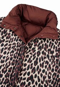 Puchový kabát s leopardím vzorom a vínovočerveným prešívaným golierom, s čiernymi a marhuľovými škvrnami na krémovom pozadí a so cvokmi.