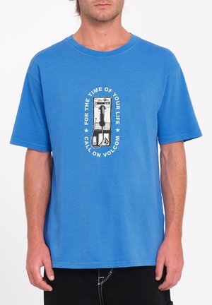 Blue cotton t-shirt featuring a central graphic of a payphone with text. Short sleeves, crew neck, relaxed fit, smooth texture.