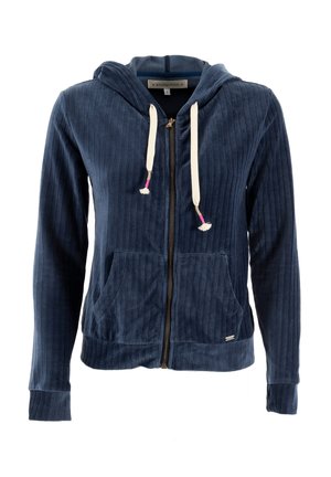 Haut à capuche zippé en velours côtelé bleu marine avec poches avant, capuche à cordon et gland de couleur claire. Présente des poignets et un ourlet côtelés.
